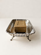 Side view of J&R EPNS footed dish showing ornate feet and patina