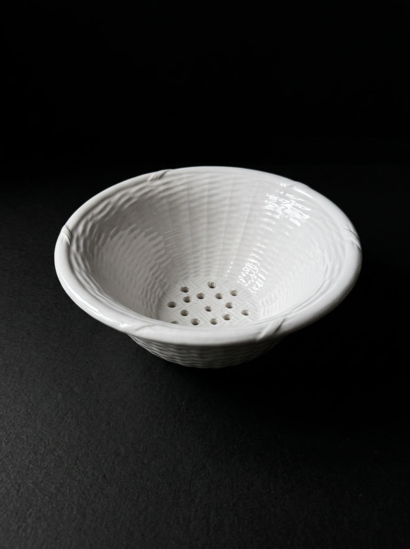 Vintage white ceramic colander on dark background