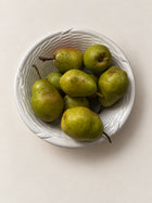 Vintage white ceramic woven bowl styled with green pears