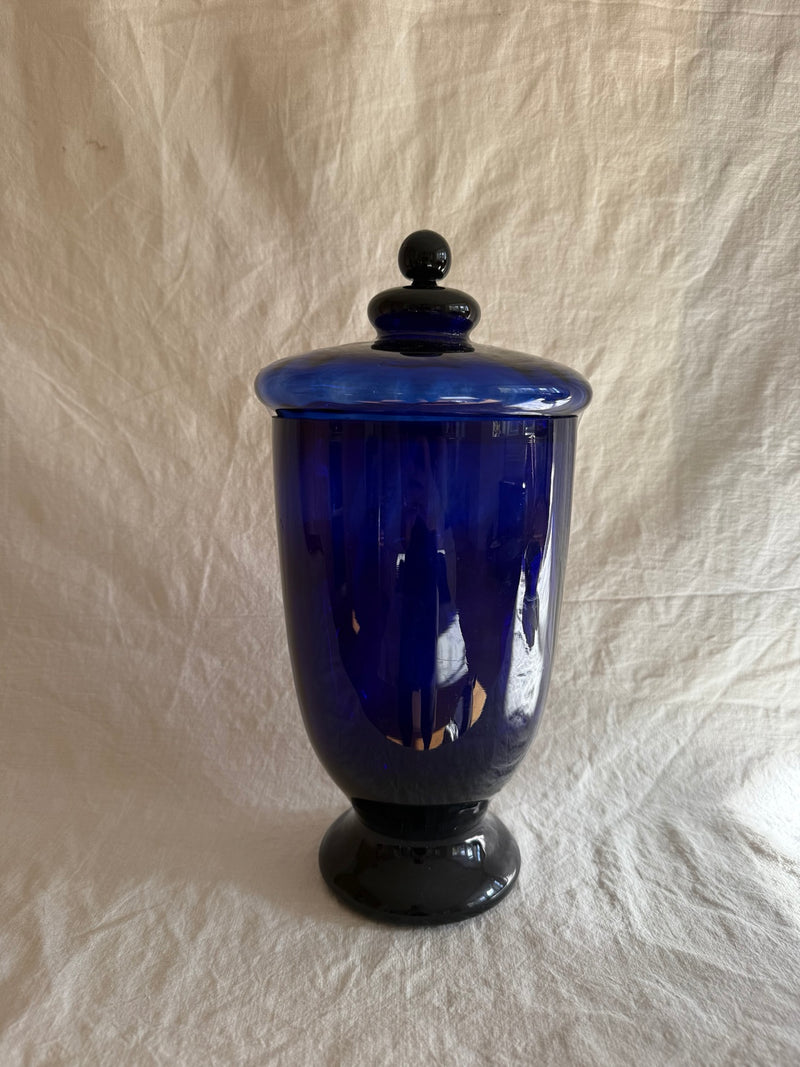 Vintage cobalt blue glass decorative lidded urn on linen backdrop