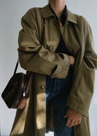 Vintage military green oversized raincoat styled with denim and vintage shoulder bag