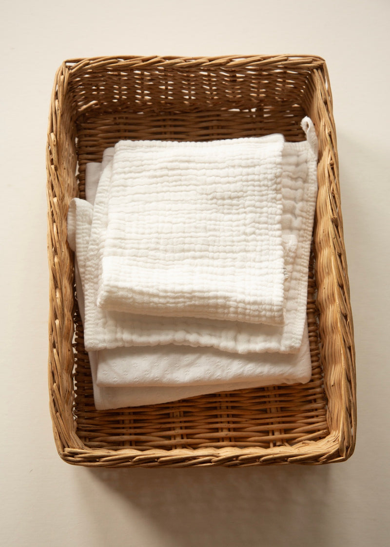 Vintage wicker decorative tray styled with folded linens